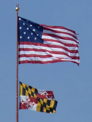 American and Maryland flags flying high over downtown Baltimore. Just why does the American flag have 15 stars and stripes? Think about Baltimore's Fort McHenry and Francis Scott Key.