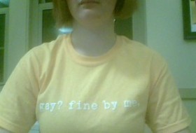 wearing a shirt that says, "Gay? Fine by me."