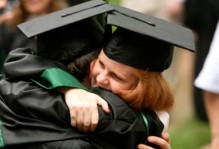 two people in cap and gowns hugging