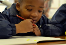 close up of a young kid with a pencil in hand