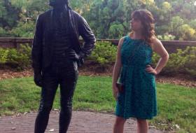 Emily Wynn standing next to a statue