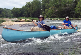 two men in a canoe on rapids