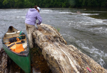Quartzite outcrop in the James River (view to the northeast). Geologist Megan Flansburg (W&M Geology ’15) measures the orientation of geologic structures. Note my 17’-canoe for scale- more on that old river-beaten canoe in my next post.