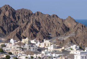 The village of Qantab, Oman with the waters of the Gulf of Oman visible in the distance. The craggy and steep hills are underlain by Cretaceous ophiolite.