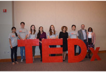 students pose behind a TEDx sign