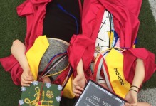Two Graduating students lying with their decorated caps covering their faces