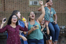 Group of female students cheering on the Homecoming Parade