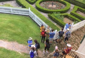 Aerial view of students standing near a fenced garden on Somerset Place Plantation
