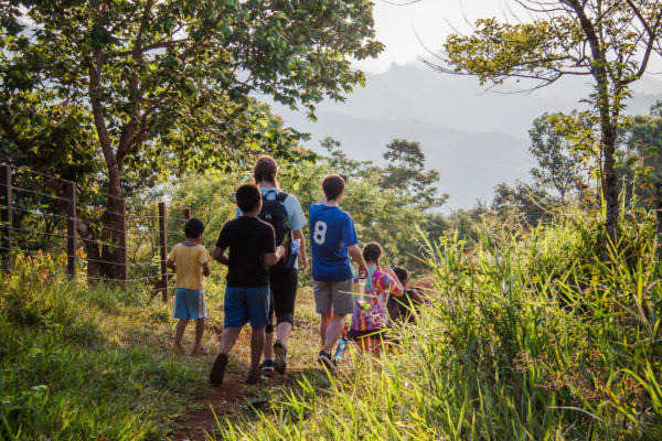Students Allie Cooper, Ethan Harrison and Sophie Harris walk with a group of Guatemalan children near a rural community.