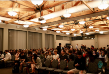 Large room in the Sadler Center with rows of seats almost entirely filledll.