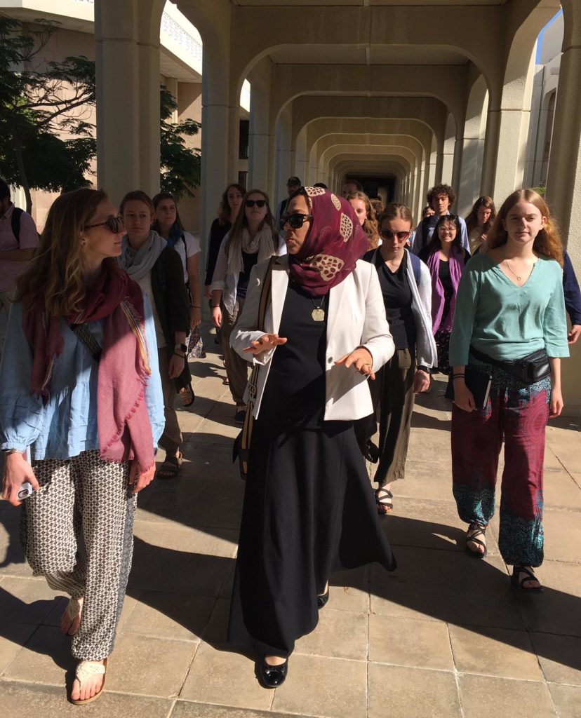 Students strolling through the campus on a covered walkway at SQU.