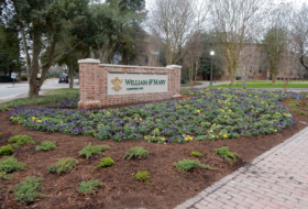 Brick and mortar William & Mary sign surrounded by mulched beds of junipers, crepe myrtles, liriope and violas
