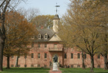 Historic brick Wren Building with the statue of Lord Botetourt in the foreground in late winter
