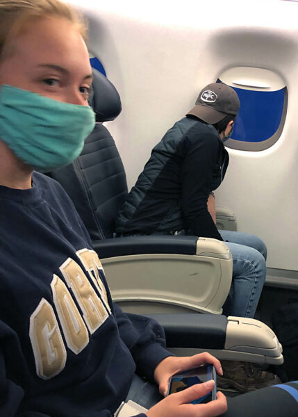 Two masked people on an airplane