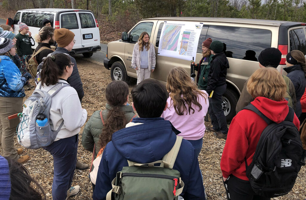 students gathered around a map affixed to a van.