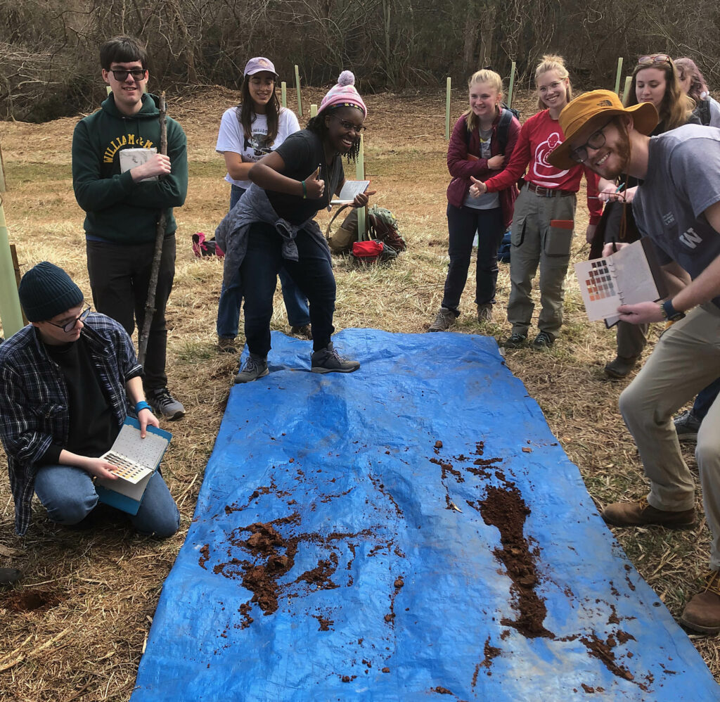 Students examining the remains of a soil core.