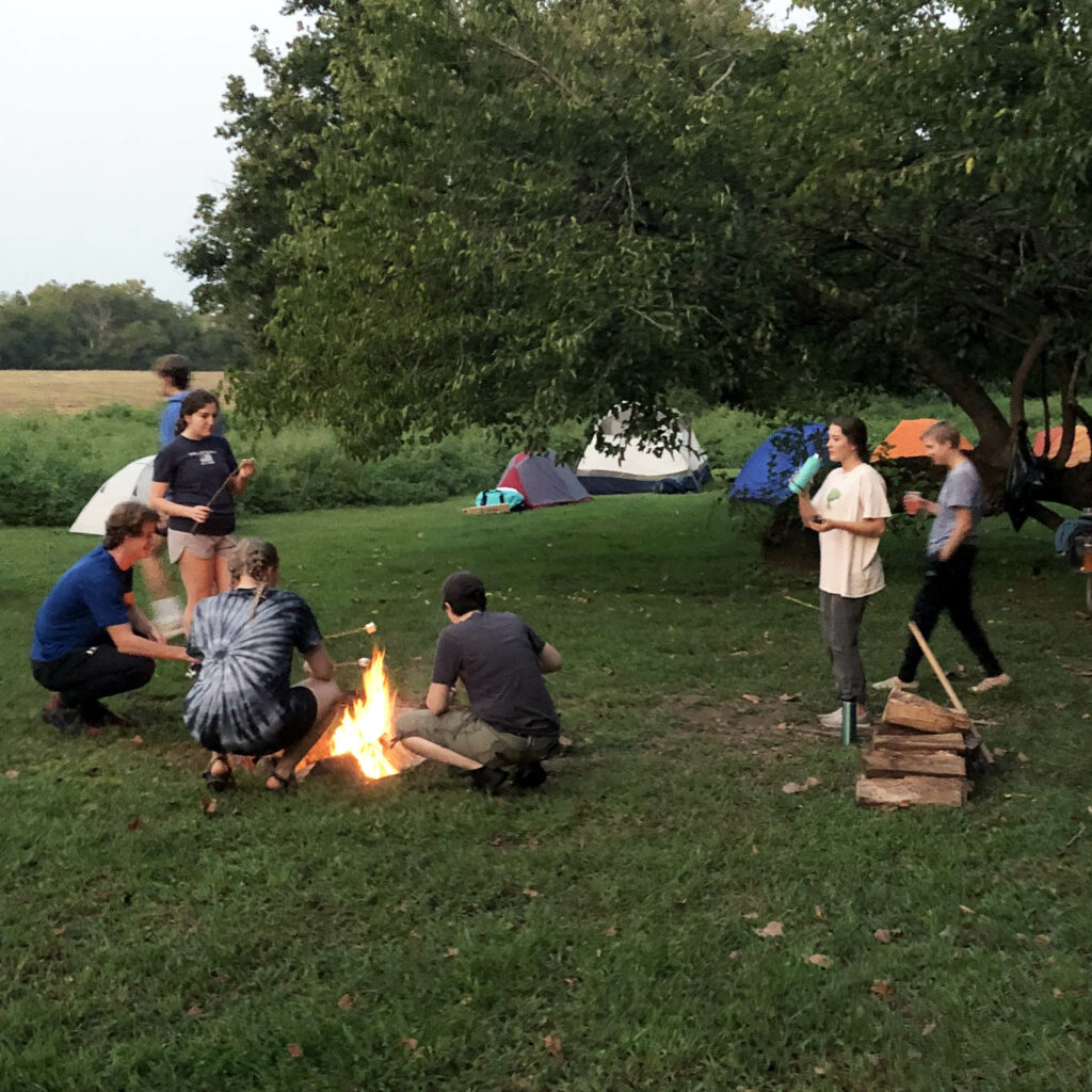Students toasting marshmallows by the campfire.