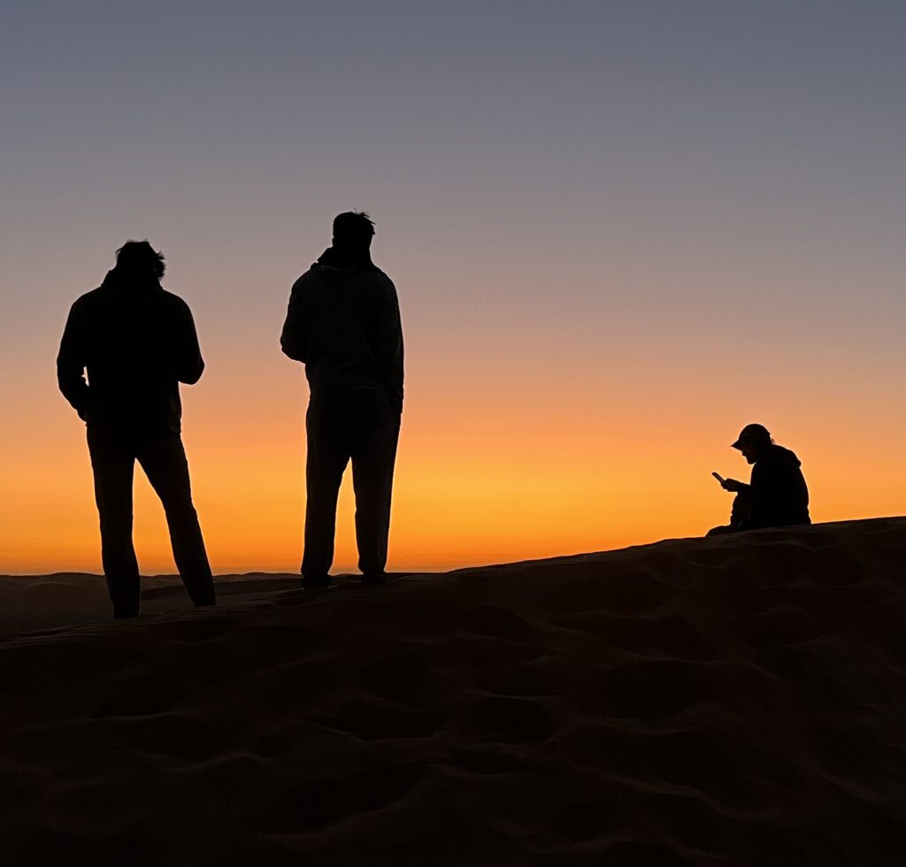 Students on a dune in the pre-dawn light.