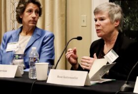 Two panelists at a table, one with a name placard of Rose Gottemoeller.